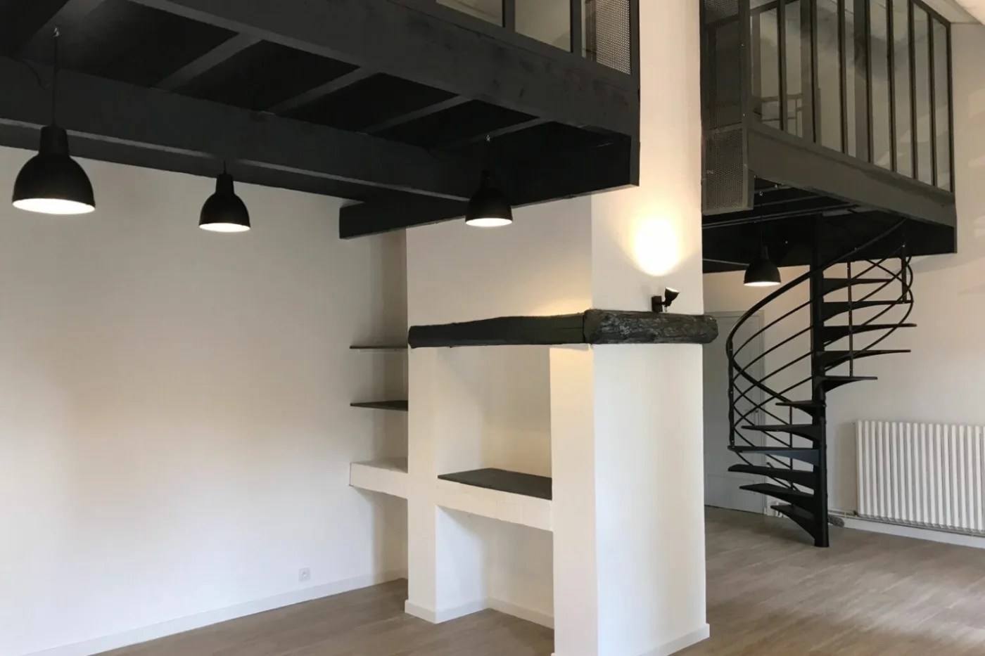 Séjour avec mezzanine métallique, escalier hélicoïdal et niches maçonnées